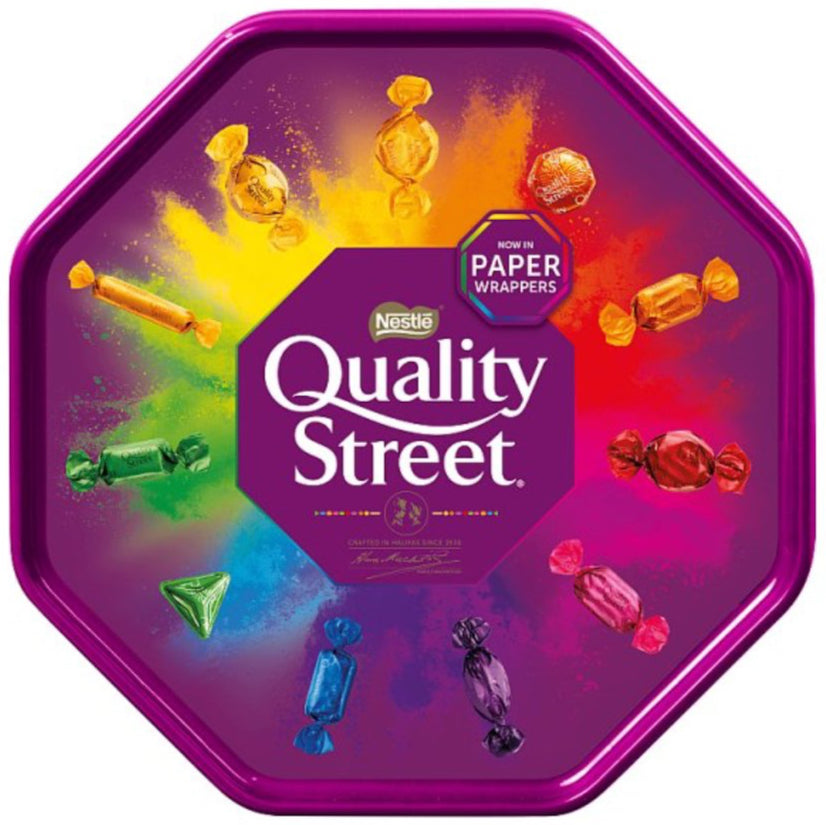 Quality Street chocolate tin with colorful candy pieces on a white background